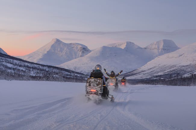 Snowmobile with sledge and husky on snow