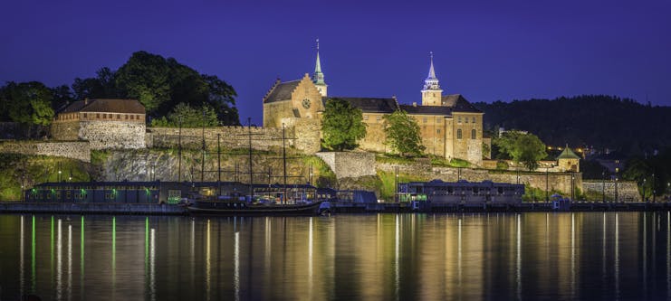 Akershus fortress castle in Oslo by water at night