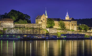 Akershus fortress castle in Oslo by water at night