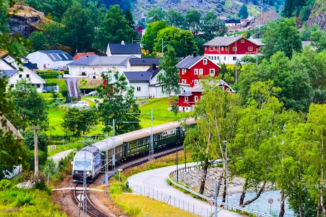 Train in country with red houses Flam to Myrdal
