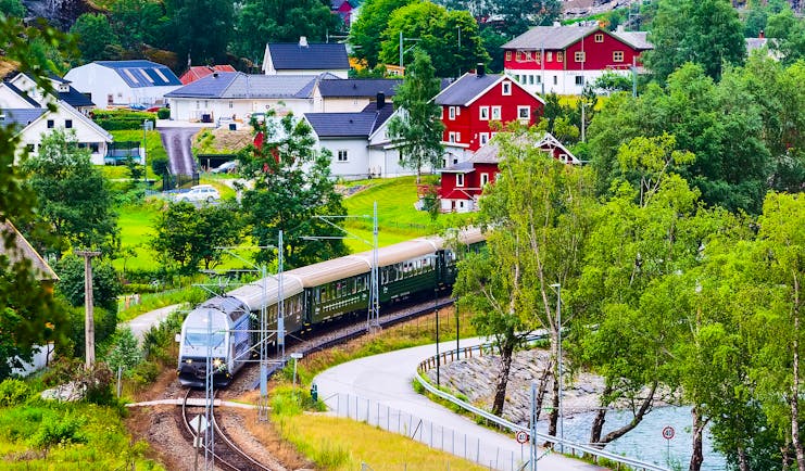 Train in country with red houses Flam to Myrdal