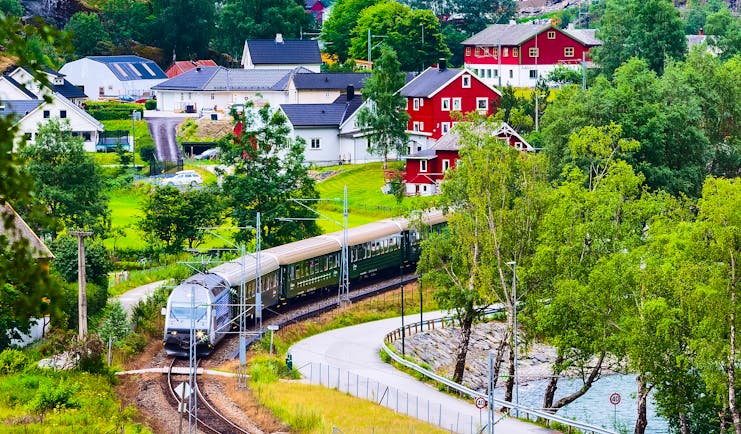 Train in country with red houses Flam to Myrdal