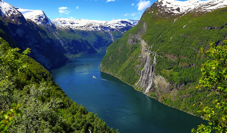 Fjord in Norway with snow capped mountains on each side