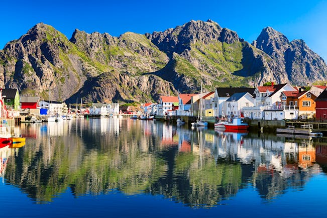 Fishing village by water with mountains behind Henningsvaer Lofoten