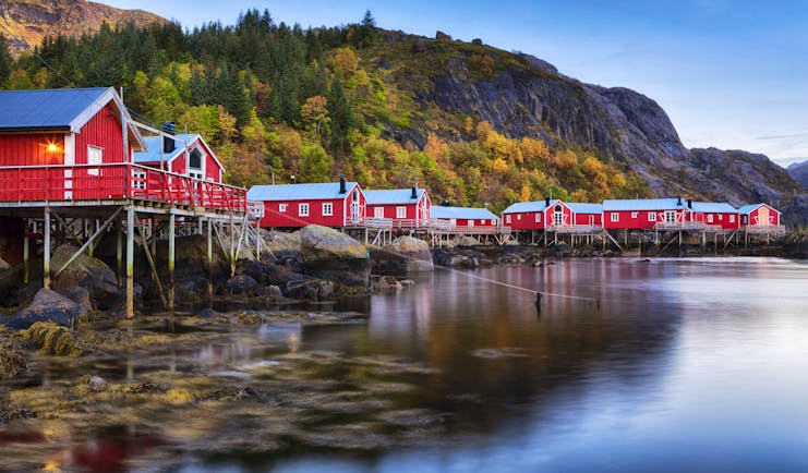 Red wooden houses on stilts over water at Nusfjord Lofoten