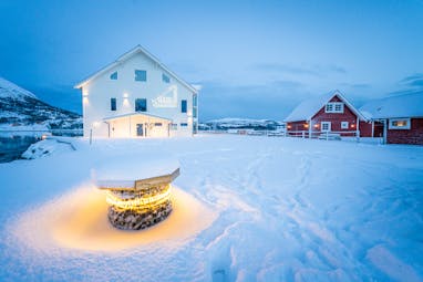 Senja Fjordhotell white and red houses in snow
