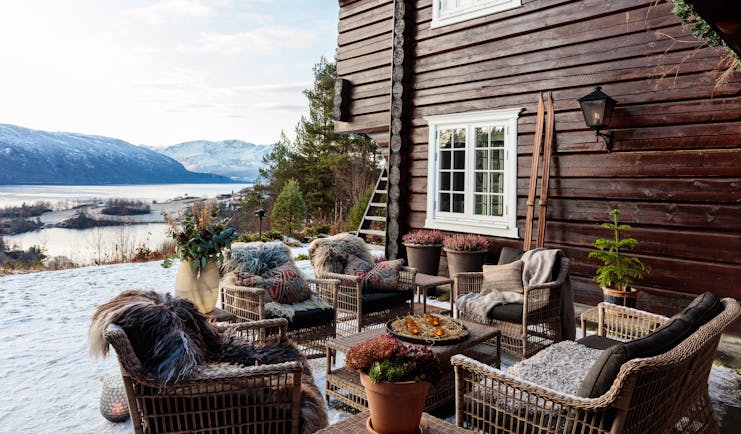 Storfjord Hotel patio with armchairs outside dark wooden house