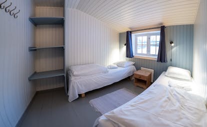 Svinoya Rorbuer bedroom with white wooden walls and small window