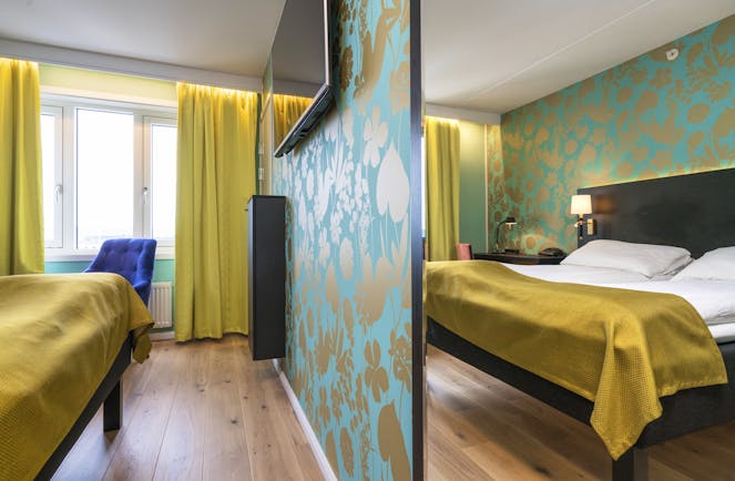 Thon Hotel Nidaros room with wooden floor, yellow curtains and bedspread and green patterned walls