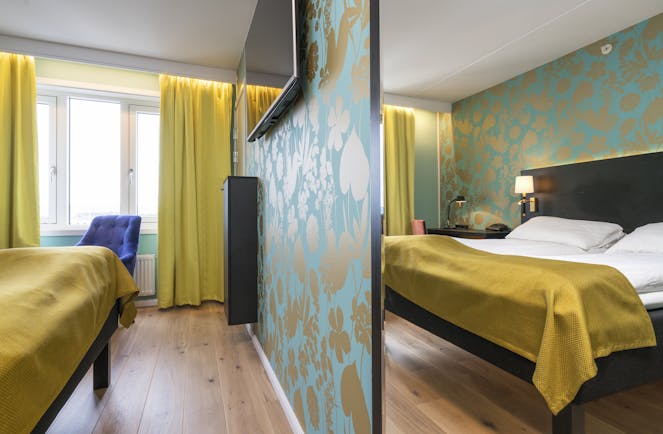 Thon Hotel Nidaros room with wooden floor, yellow curtains and bedspread and green patterned walls