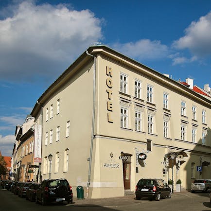 White plastered exterior of two storey hotel on corner of road Hotel Amadeus Krakow