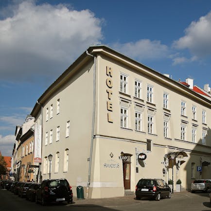 White plastered exterior of two storey hotel on corner of road Hotel Amadeus Krakow