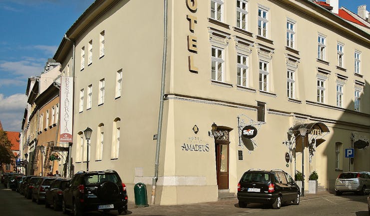 White plastered exterior of two storey hotel on corner of road Hotel Amadeus Krakow