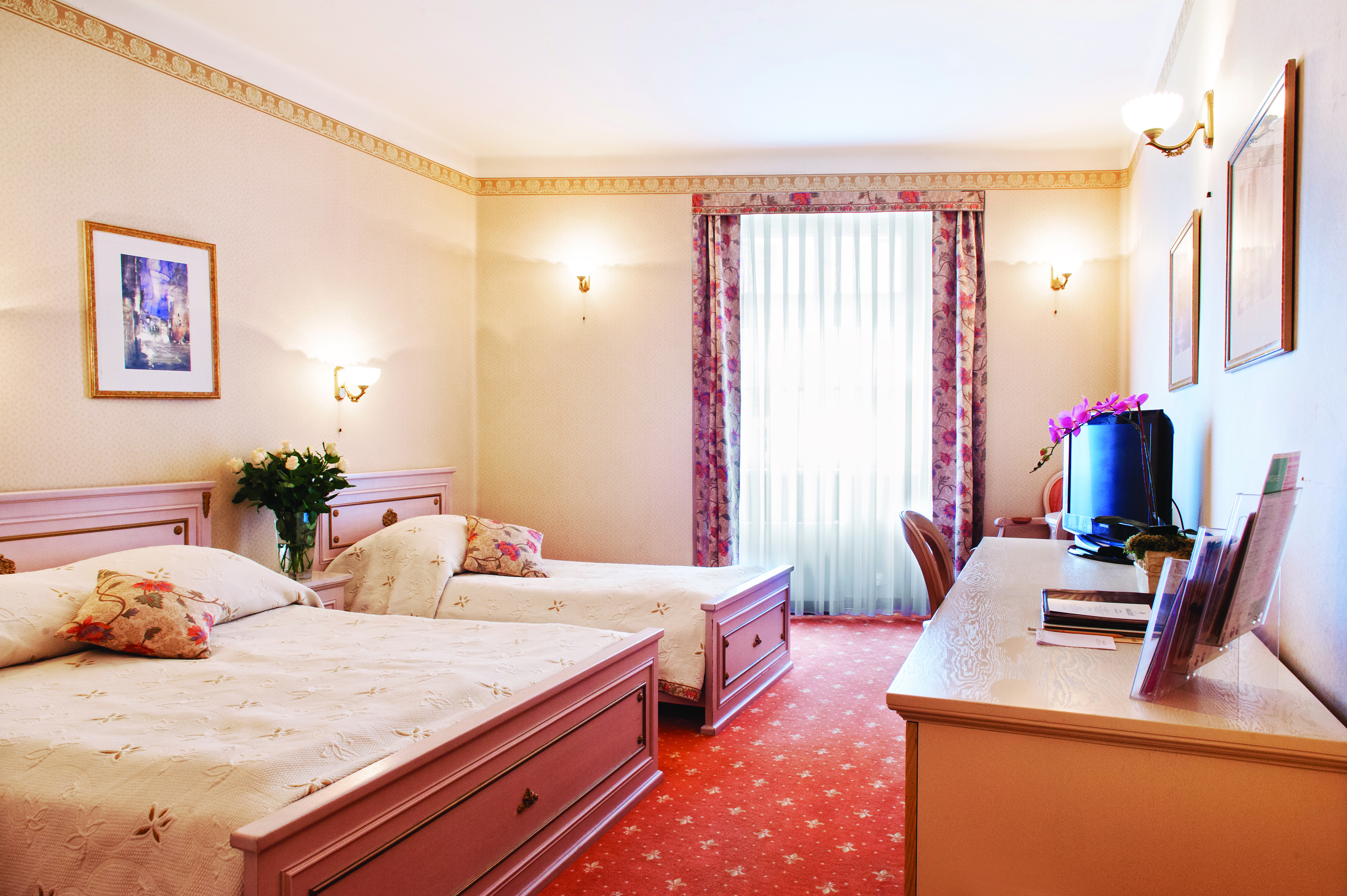 Twin room with two double beds, a television, and curtains