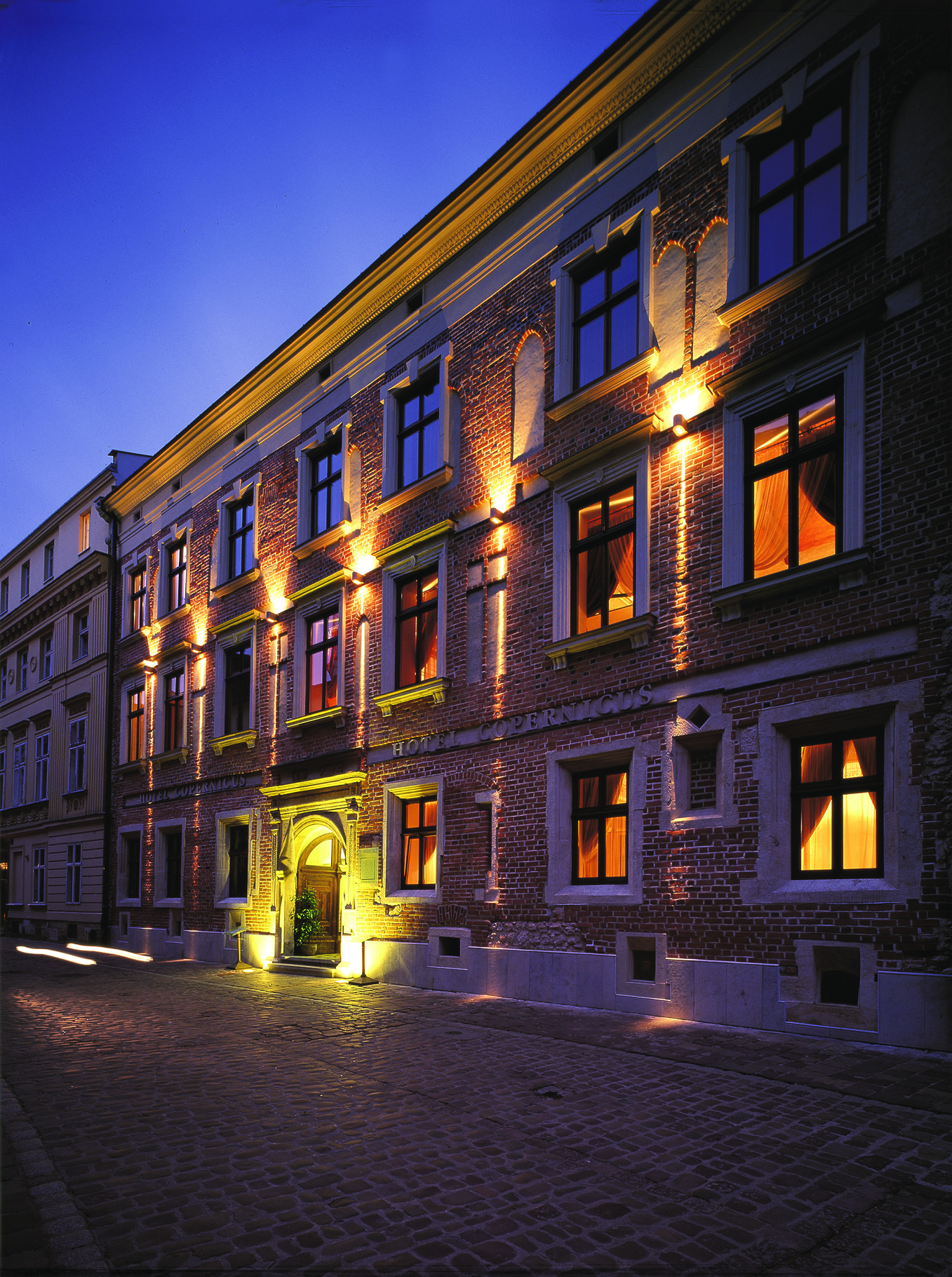 Hotel Copernicus Krakow exterior stone building with large windows and an arched entrance