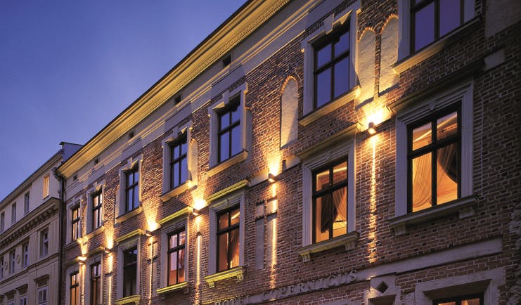 Hotel Copernicus Krakow exterior stone building with large windows and an arched entrance
