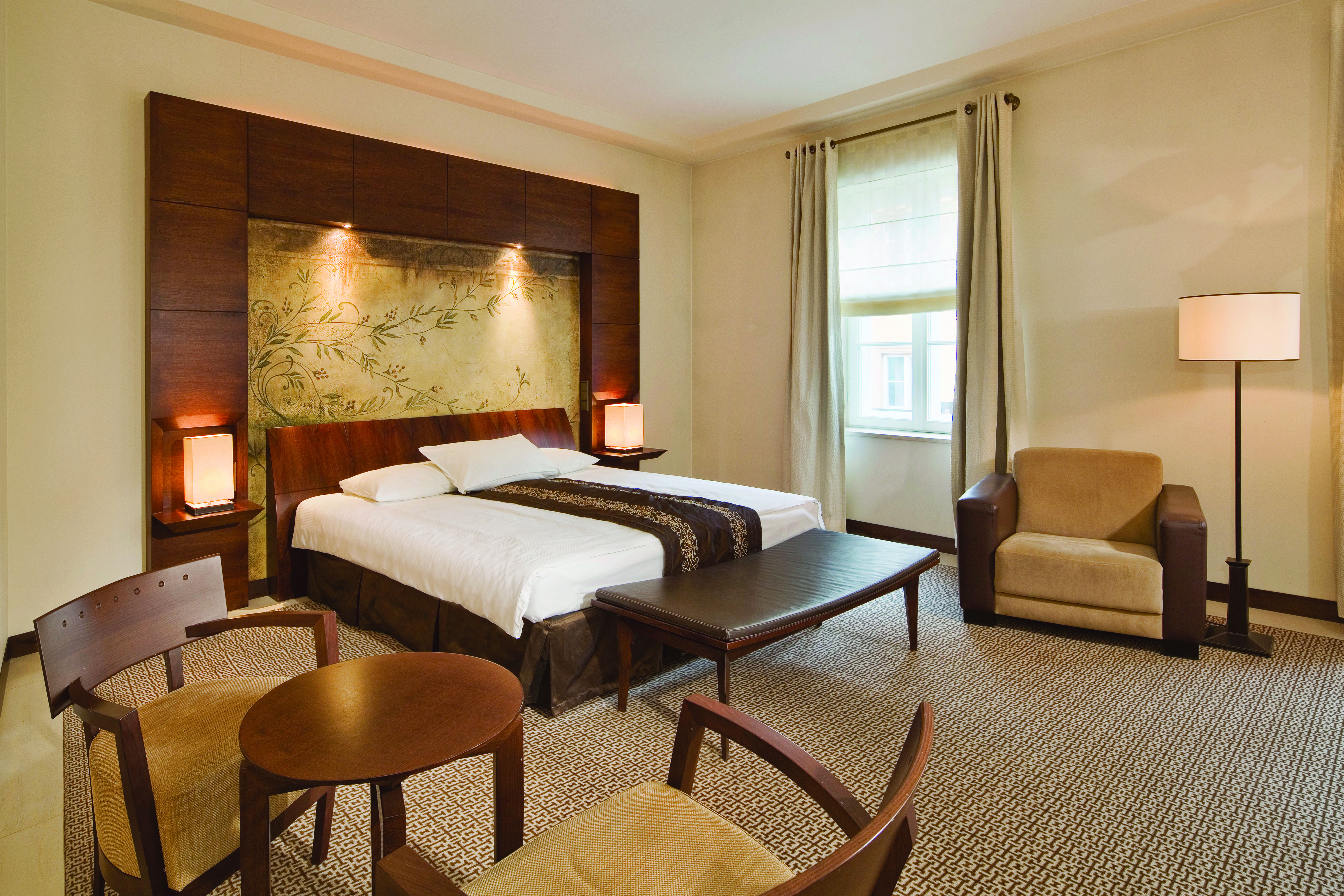 Mamaison Le Regina Warsaw superior bedroom  wooden headboard and painting of vines table and chairs