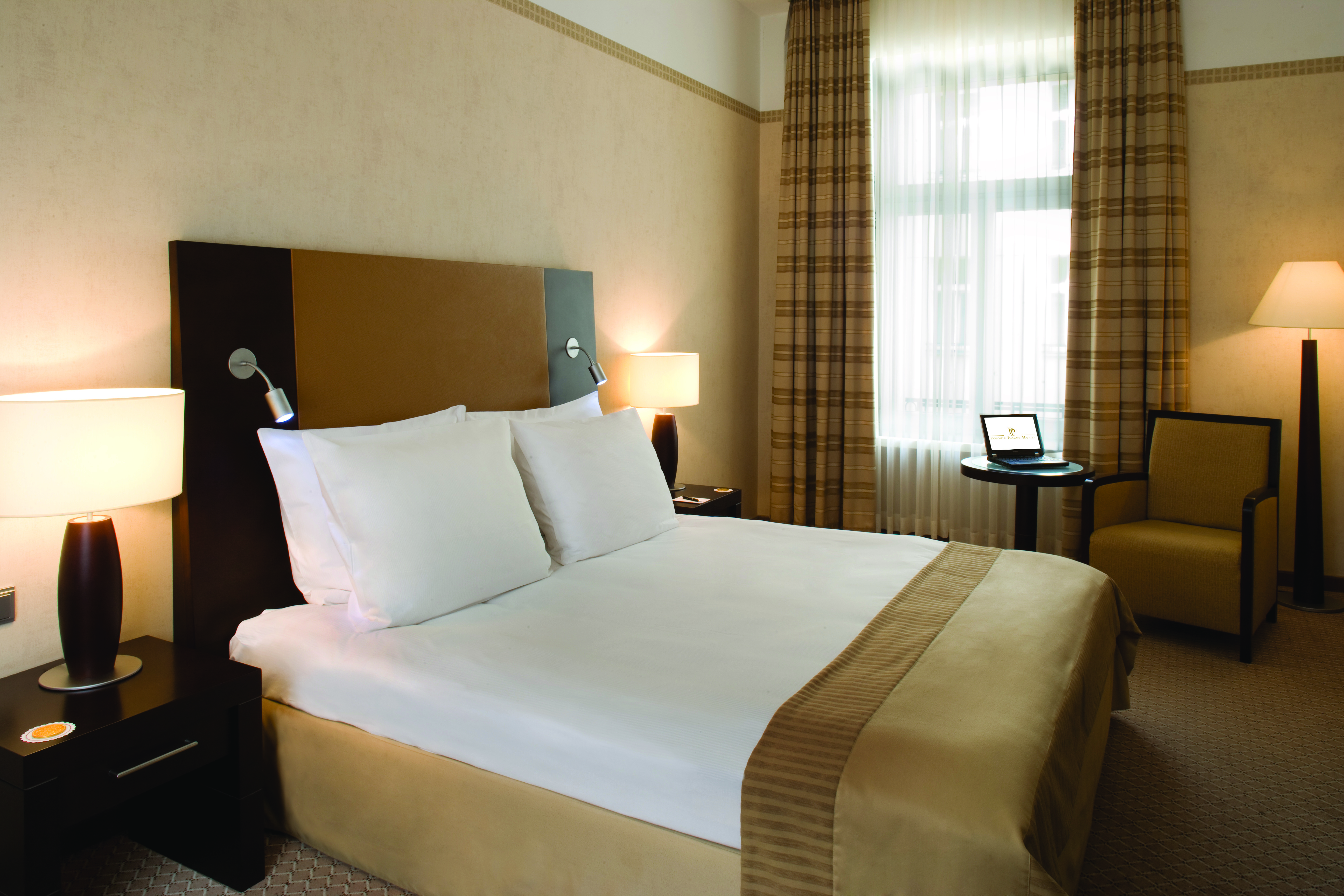 Polonia Palace Hotel standard king room with large bed, a big window and brown and beige colour scheme