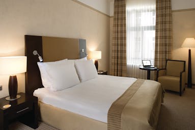 Polonia Palace Hotel standard king room with large bed, a big window and brown and beige colour scheme