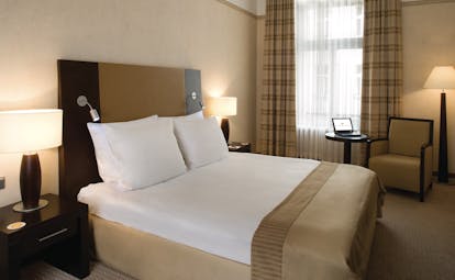 Polonia Palace Hotel standard king room with large bed, a big window and brown and beige colour scheme