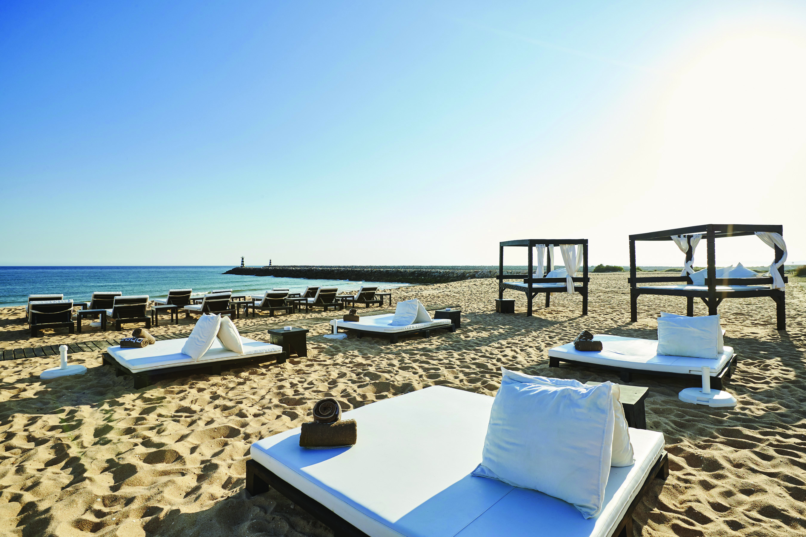 View of the hotel's beach with white sunbeds 