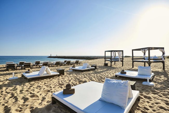 View of the hotel's beach with white sunbeds 