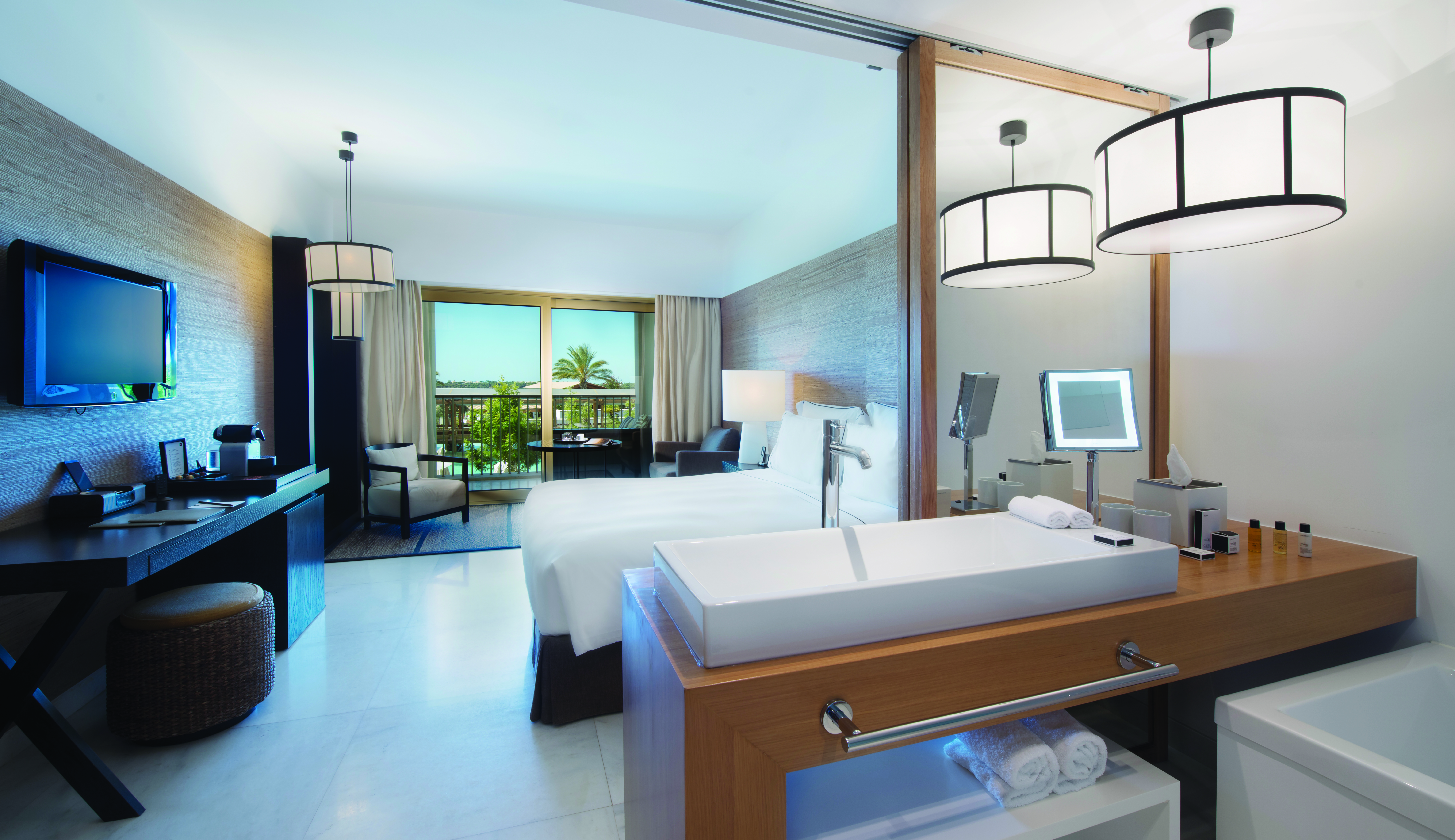 Deluxe double room with television, and view looking out onto the pool 