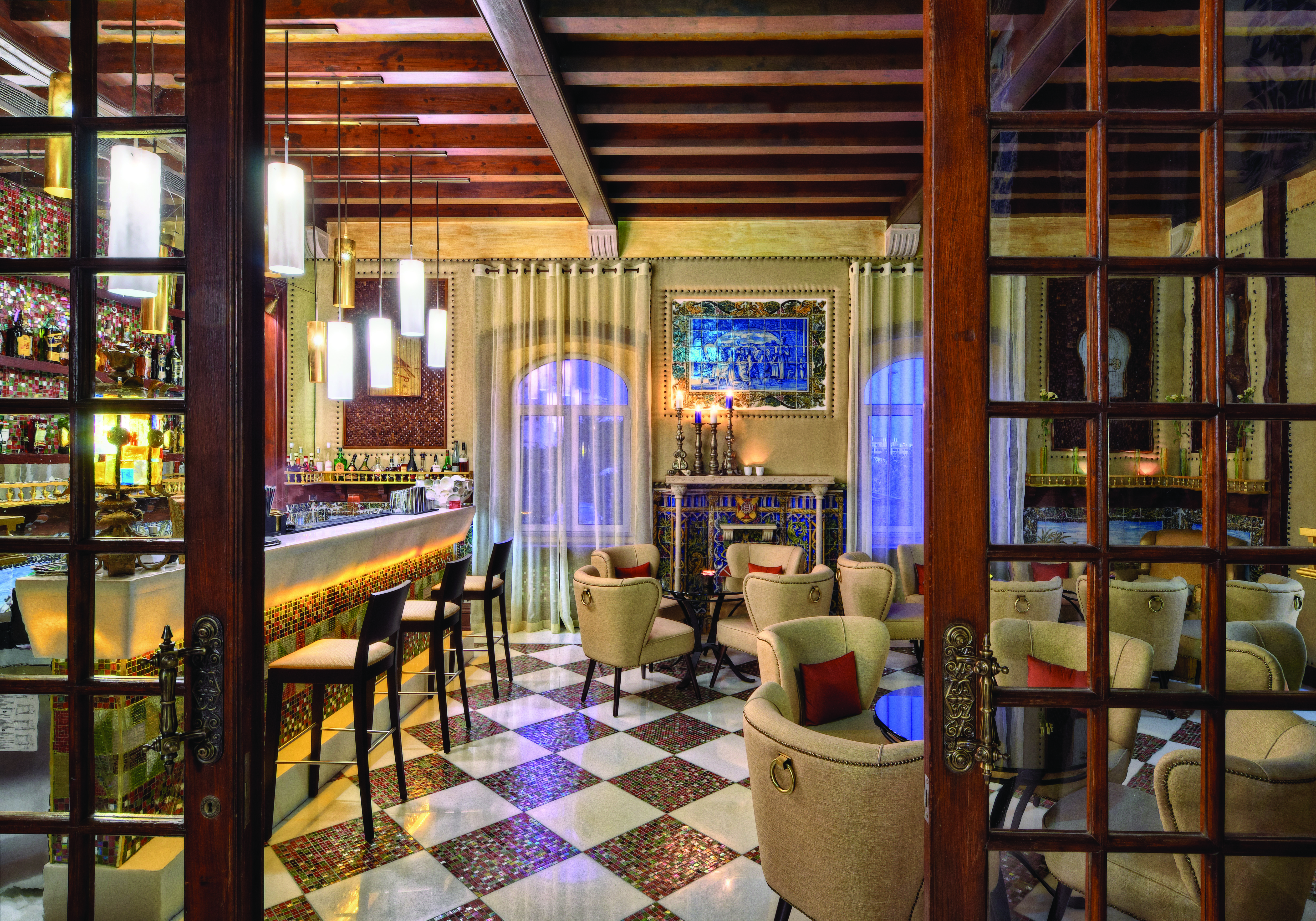 View of the Bela Vista Hotel & Spa with wooden ceilings, tiled floors, wooden high bar chairs and beige coloured arm chairs for seating