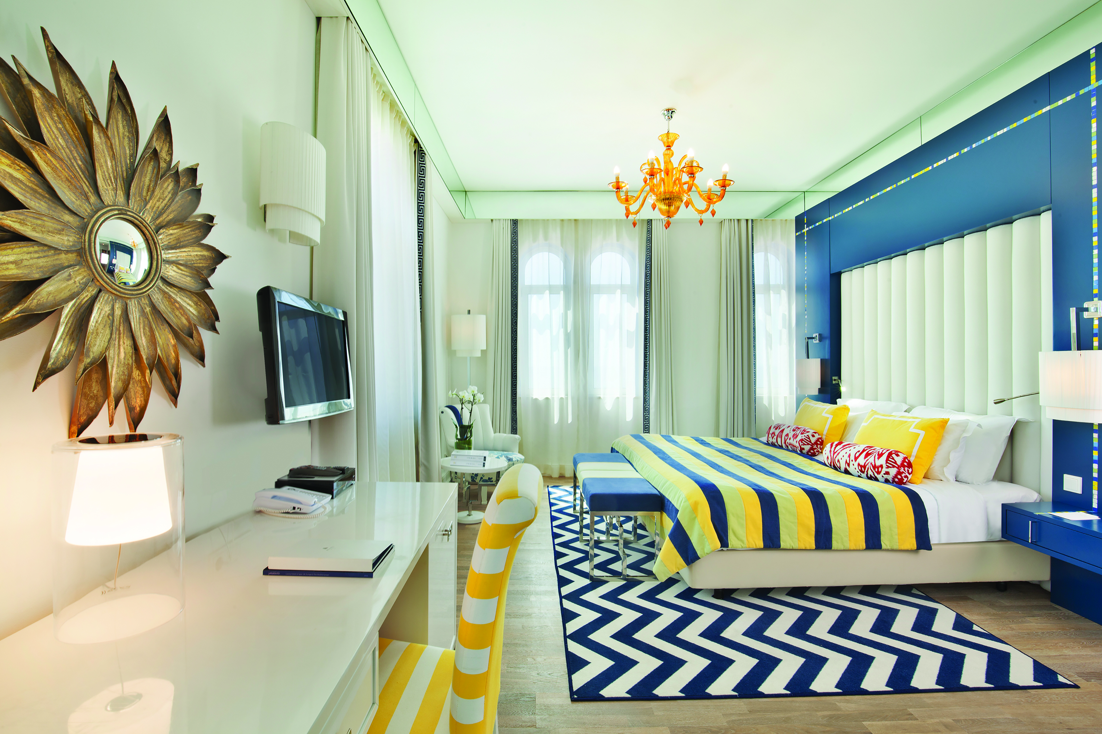 View of the Bela Vita Hotel & Spa Character room with a double bed and television decorated in yellow and navy