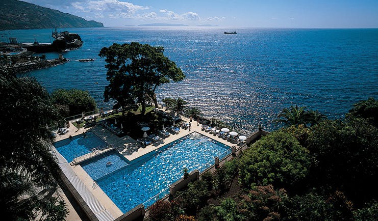 Belmond Reid's Palace Portugal aerial outdoor pool trees loungers umbrellas sea view