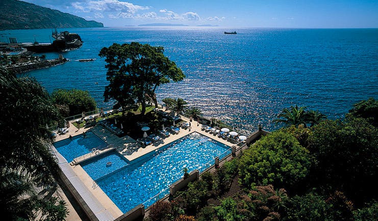 Belmond Reid's Palace Portugal aerial outdoor pool trees loungers umbrellas sea view