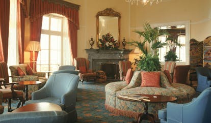 Belmond Reid's Palace Portugal guest lounge traditional decor armchairs fireplace chandelier