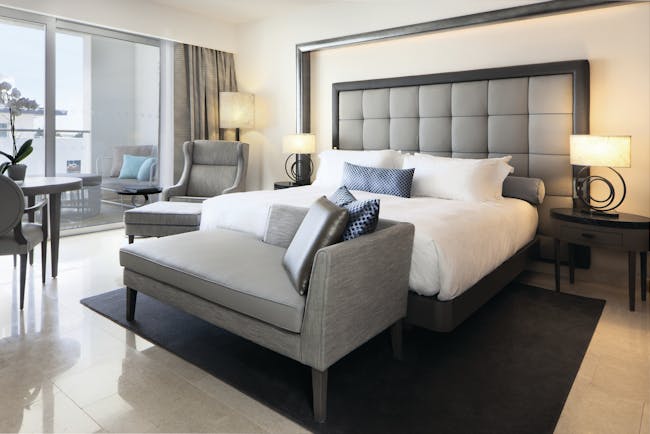 Conrad Algarve deluxe room, bed armchair, bright modern decor, balcony