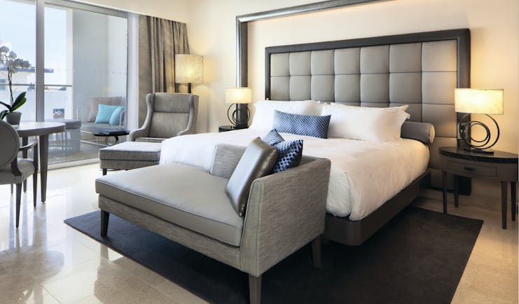 Conrad Algarve deluxe room, bed armchair, bright modern decor, balcony