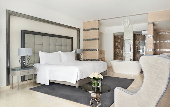 Conrad Algarve grand deluxe room, large bed, armchair, bath, comfortable modern decor