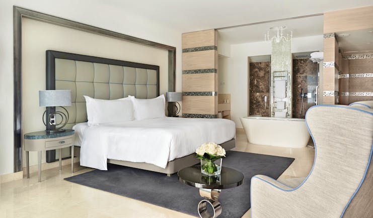 Conrad Algarve grand deluxe room, large bed, armchair, bath, comfortable modern decor