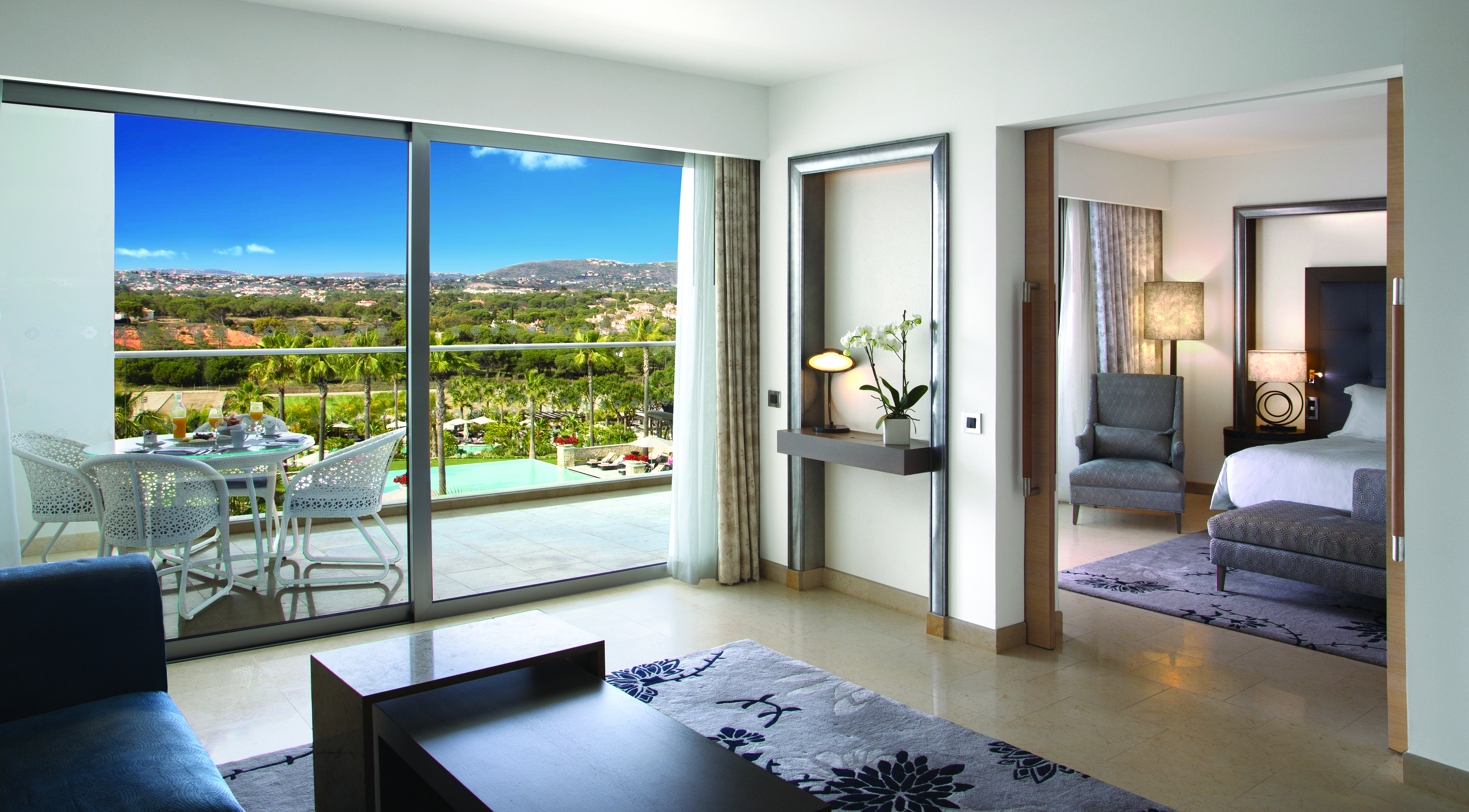 Conrad Algarve grand deluxe suite, bedroom conneted to living area, bright modern decor, balcony with view over pool