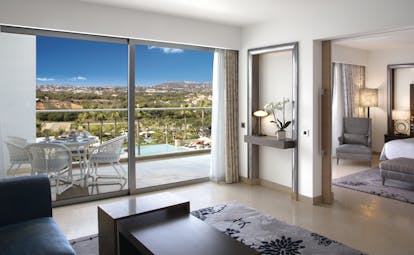 Conrad Algarve grand deluxe suite, bedroom conneted to living area, bright modern decor, balcony with view over pool