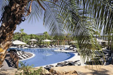 Conrad Algarve outdoor pool, sun loungers and umbrellas, palm trees