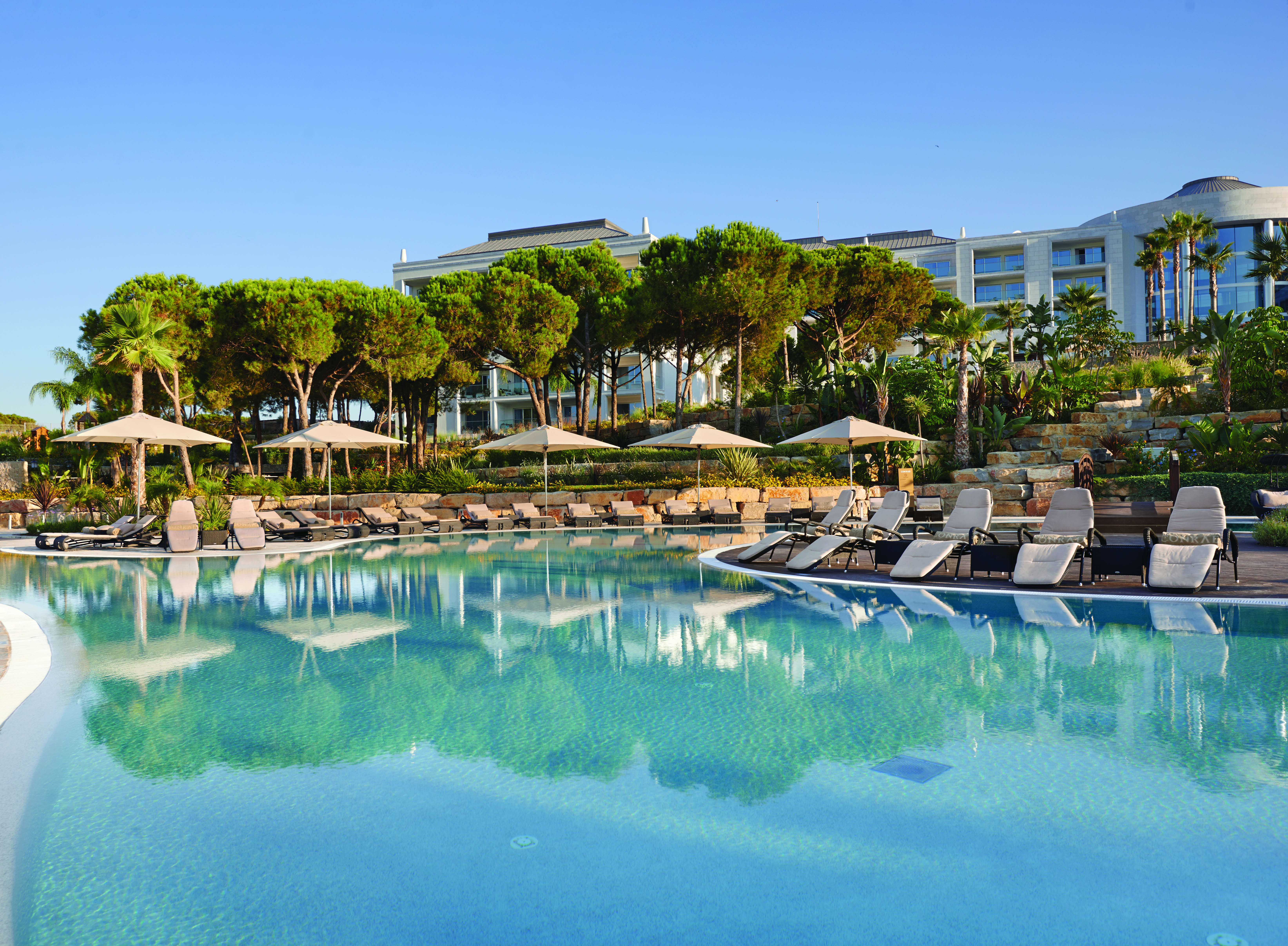 Conrad Algarve swimming pool, sun loungers, trees, outdoor pool
