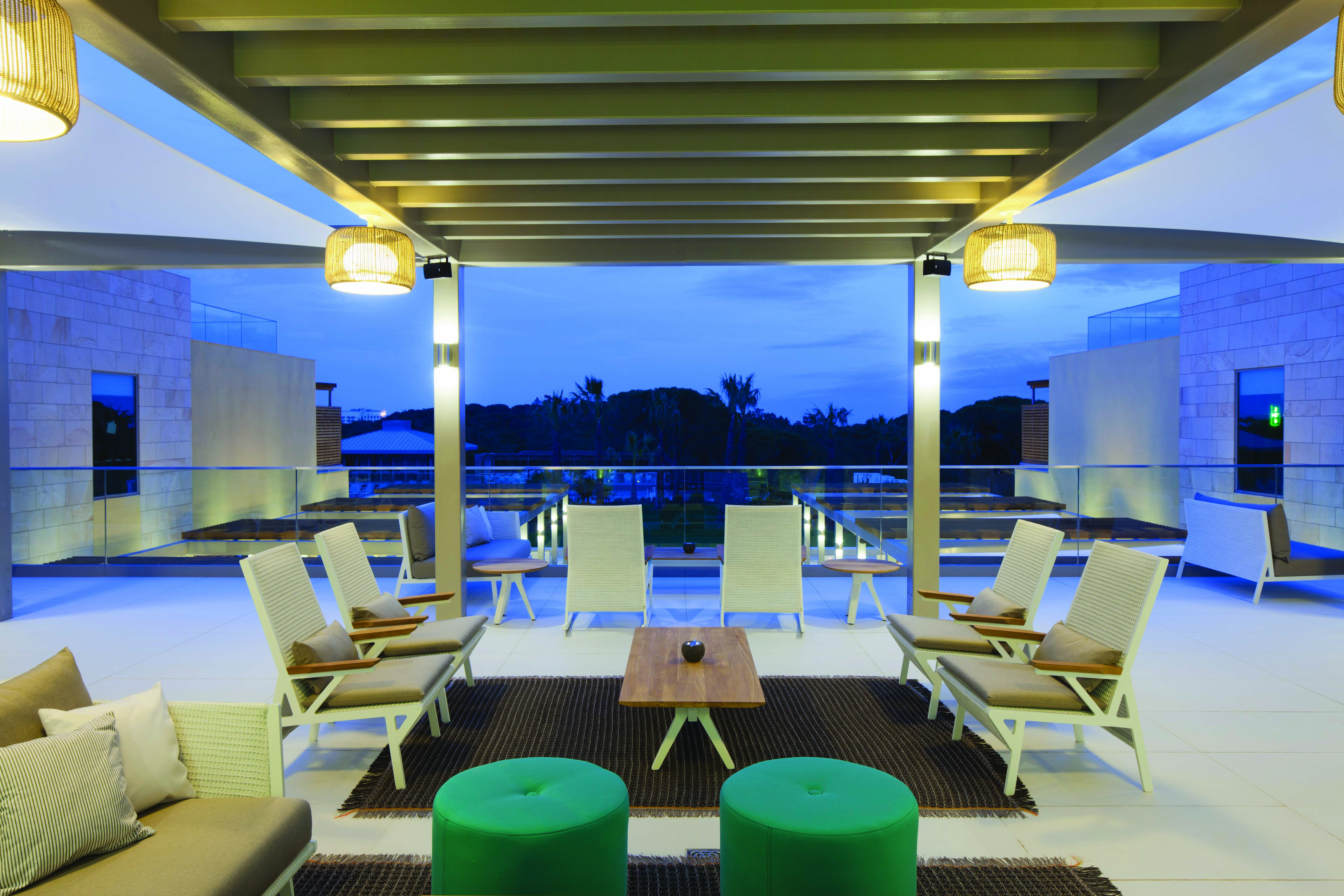 Epic Sana terrace bar on hotel roof, modern chairs and green footstools