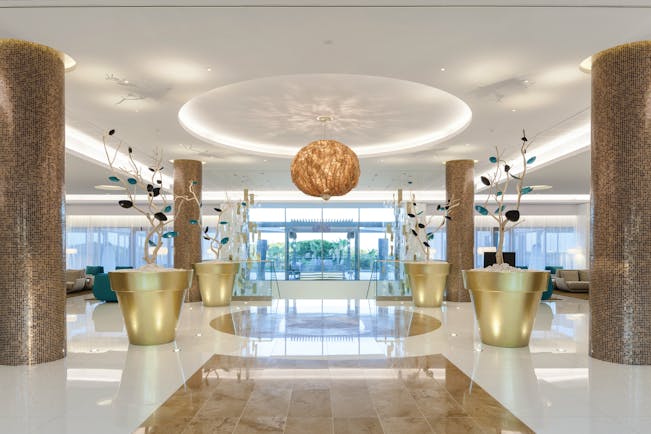 Epic Sana lobby, modern decor, marble floors and columns, colourful flower sculptures