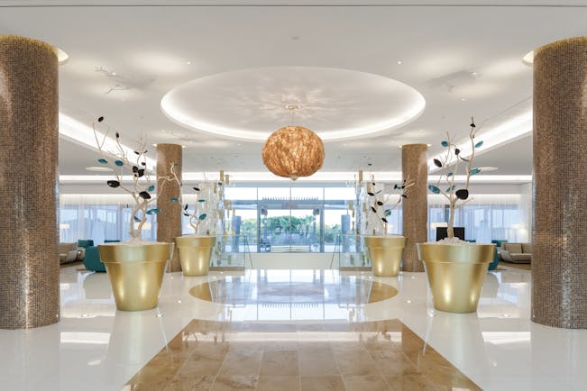 Epic Sana lobby, modern decor, marble floors and columns, colourful flower sculptures