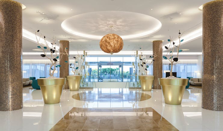 Epic Sana lobby, modern decor, marble floors and columns, colourful flower sculptures