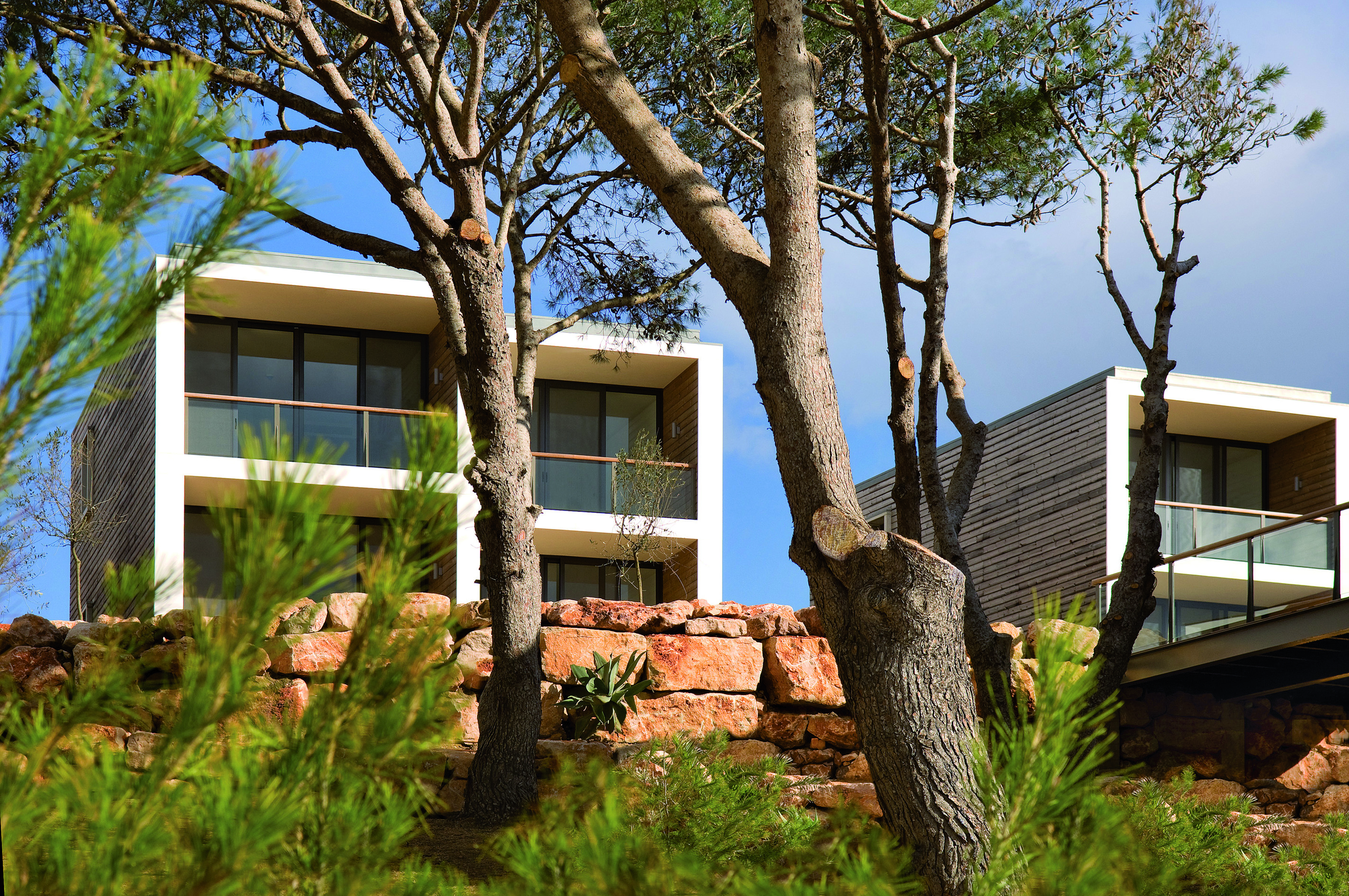 View of the Martinhal Beach Resort and Hotel from behind a tree in daylight 