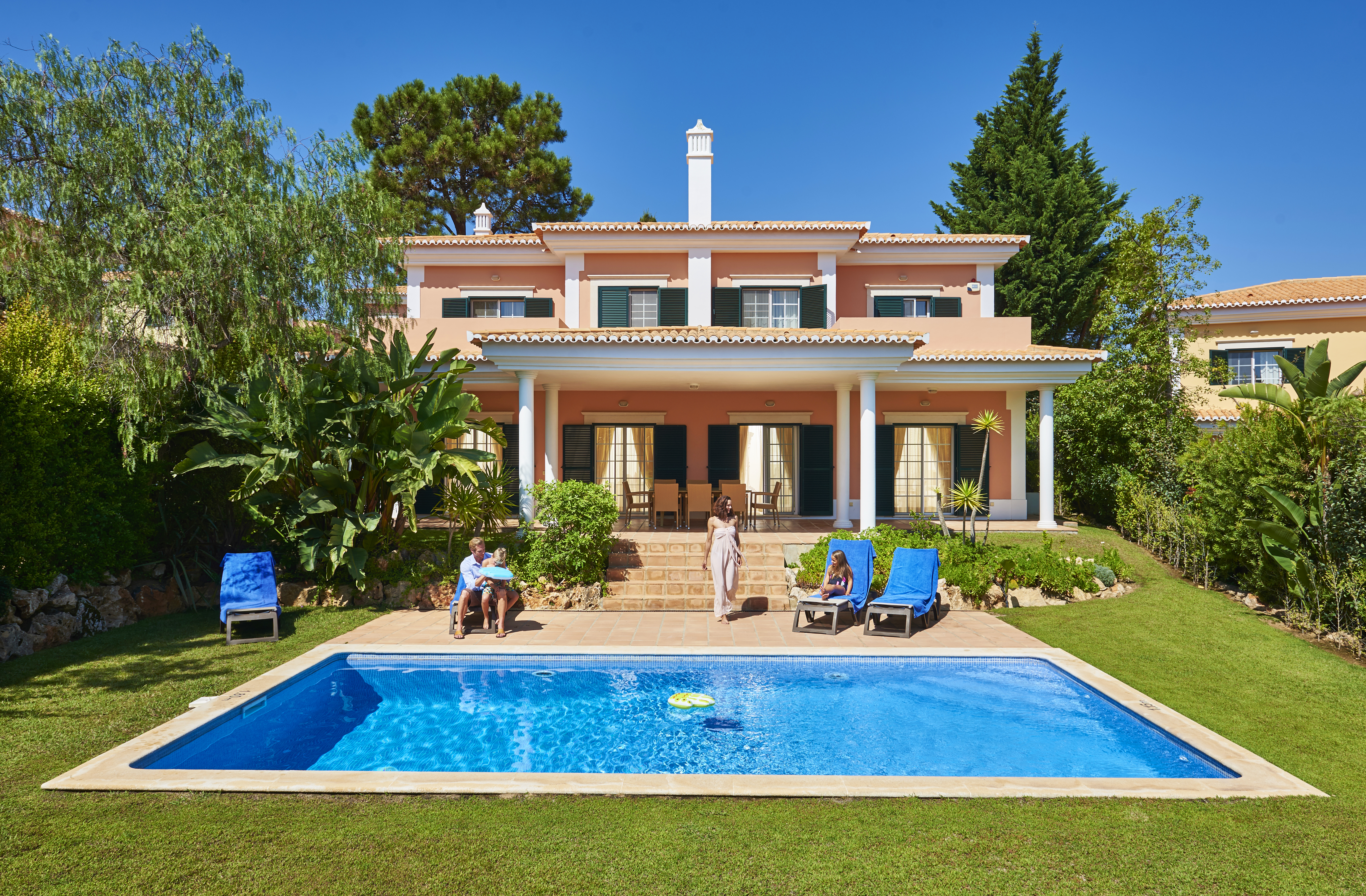 Martinhal Quinta Portugal luxury villa exterior private pool and family sitting in garden