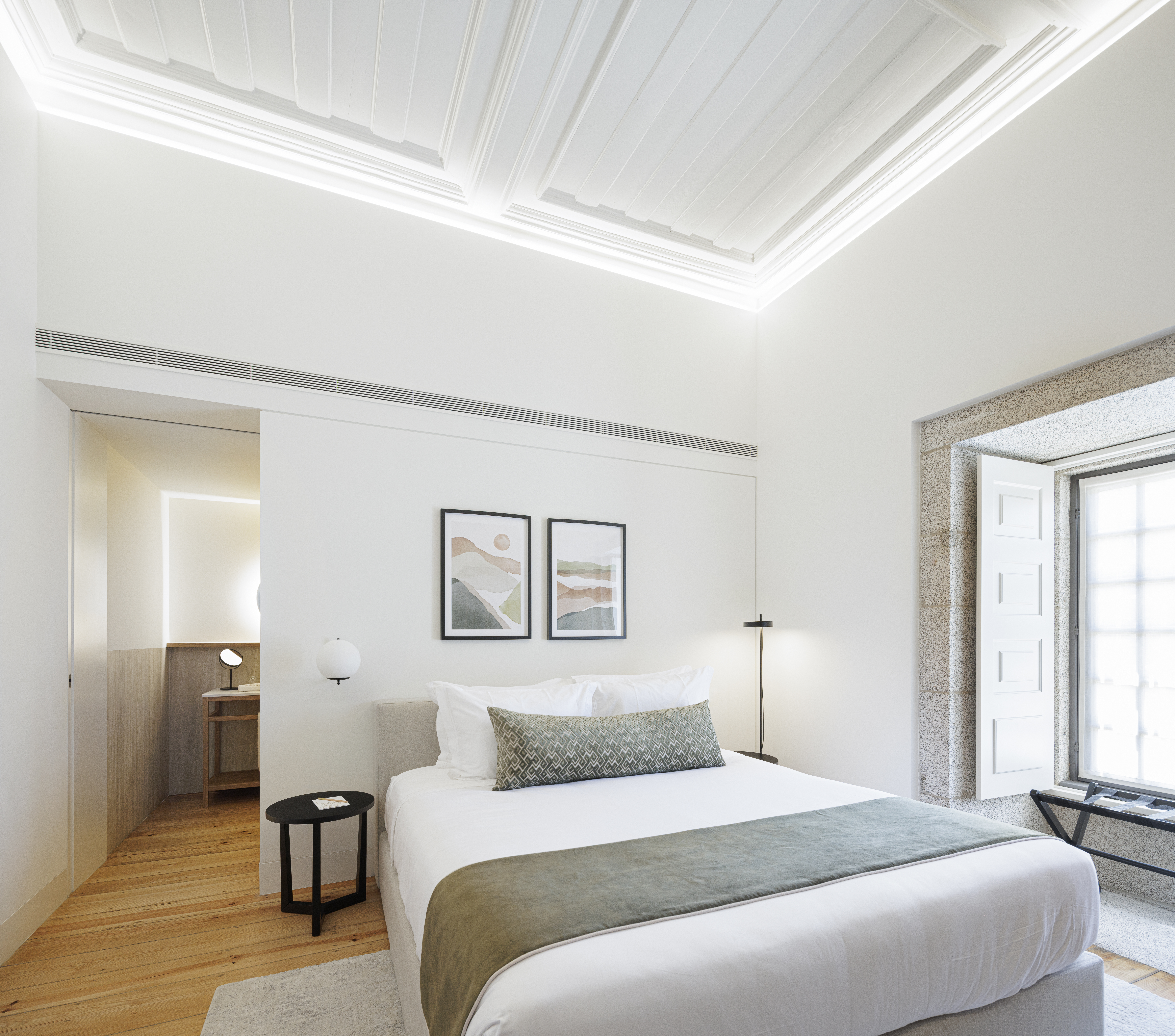Mosterio de Arouca room with neutral colour palette, high ceilings, white walls, wooden floor, and stone-framed windows