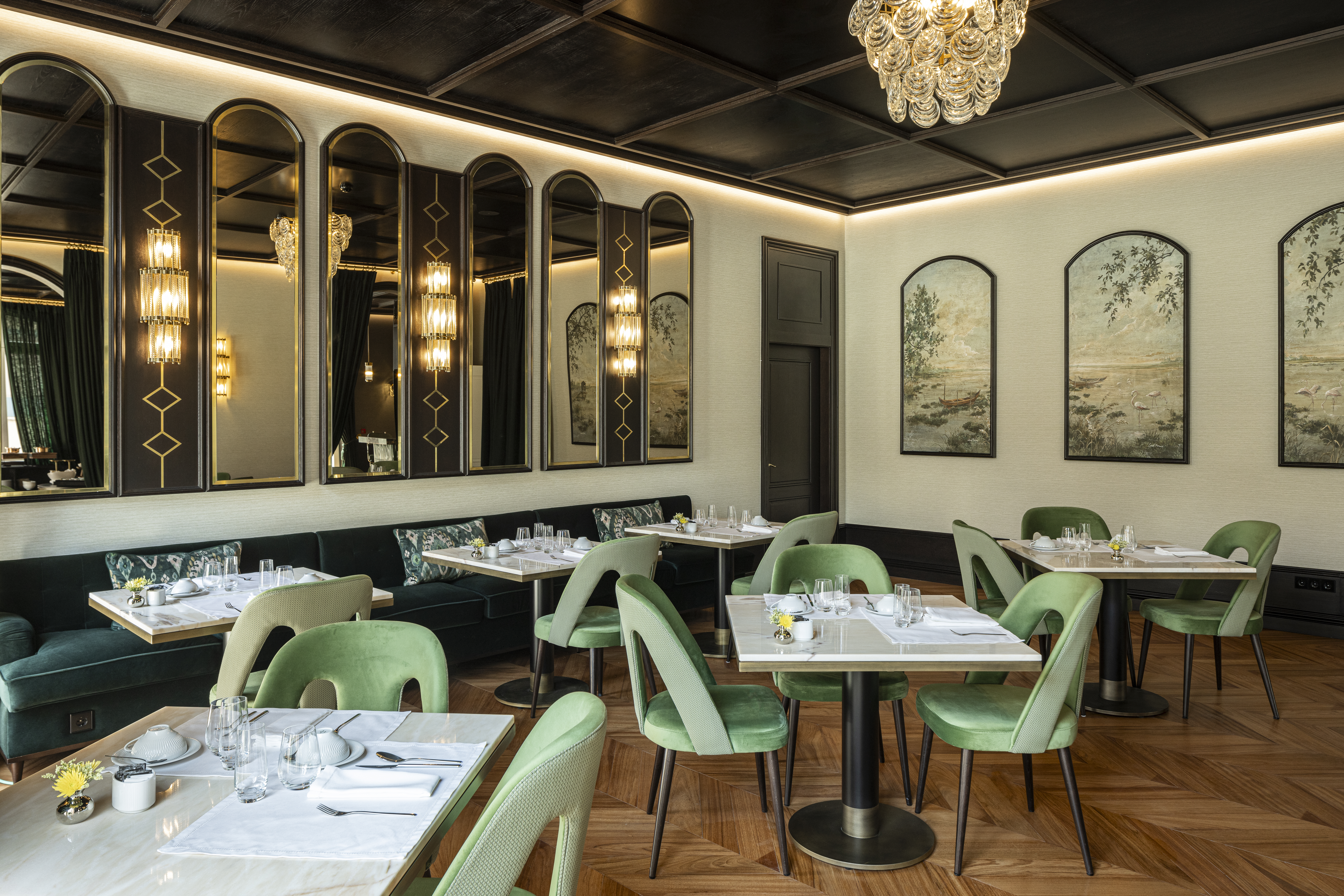 Palacete de Valdemouro restaurant, with high ceilings, mirrors and contemporary art on the walls, oak herringbone floor, and pale green chairs and white tables