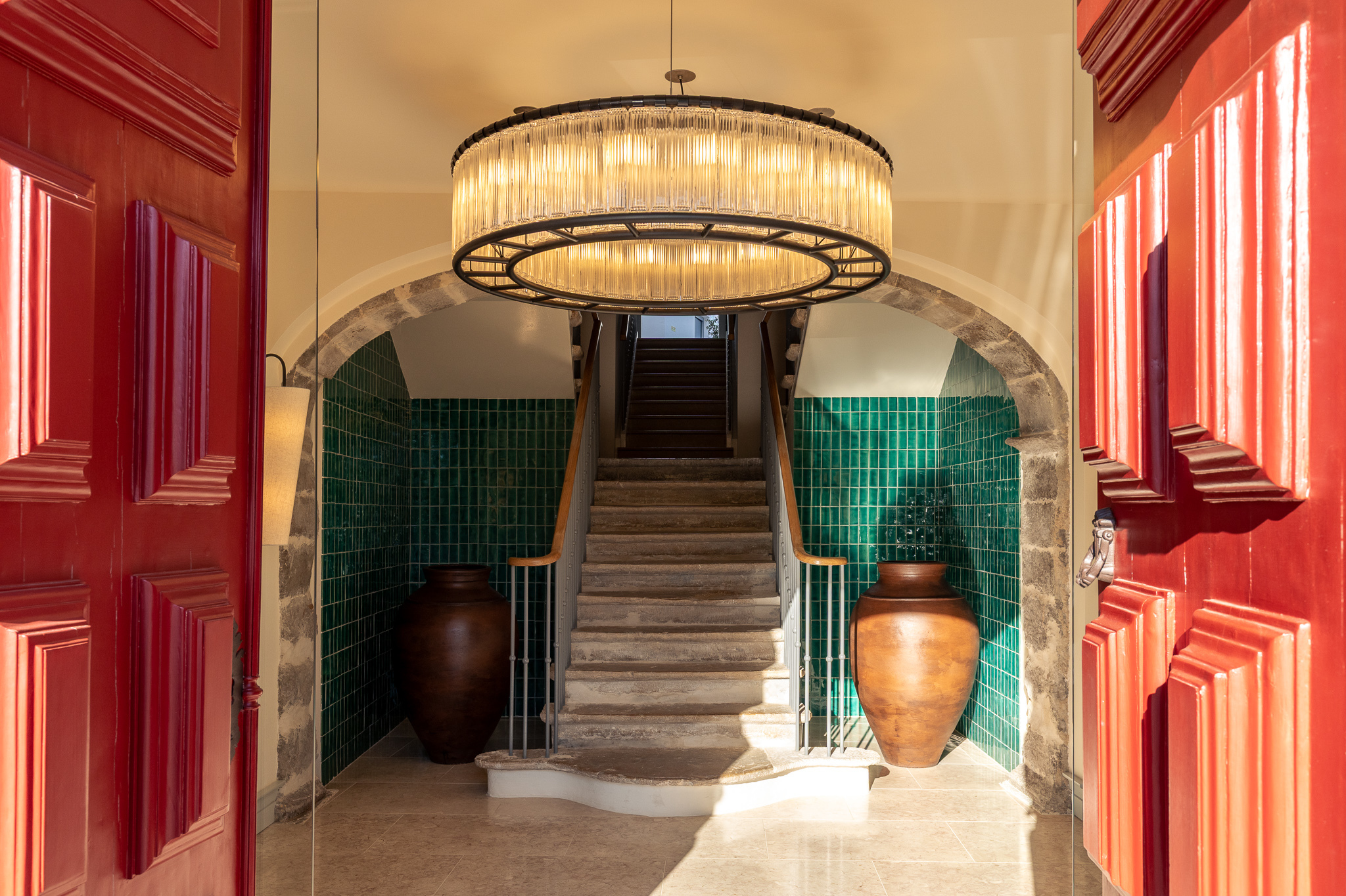 Palacio de Tavira Reception with heavy red doors, authentic archway, stone steps, and green tiles on the walls