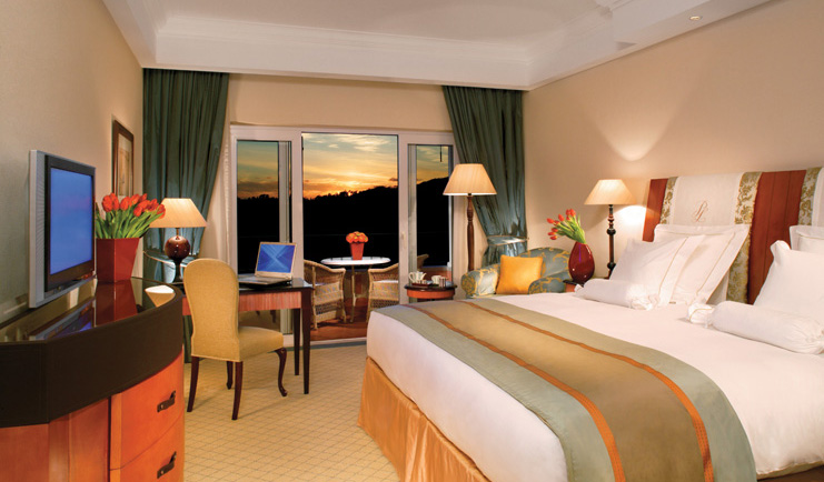 Penha Longa Portugal bedroom with desk and patio doors to balcony at sunset